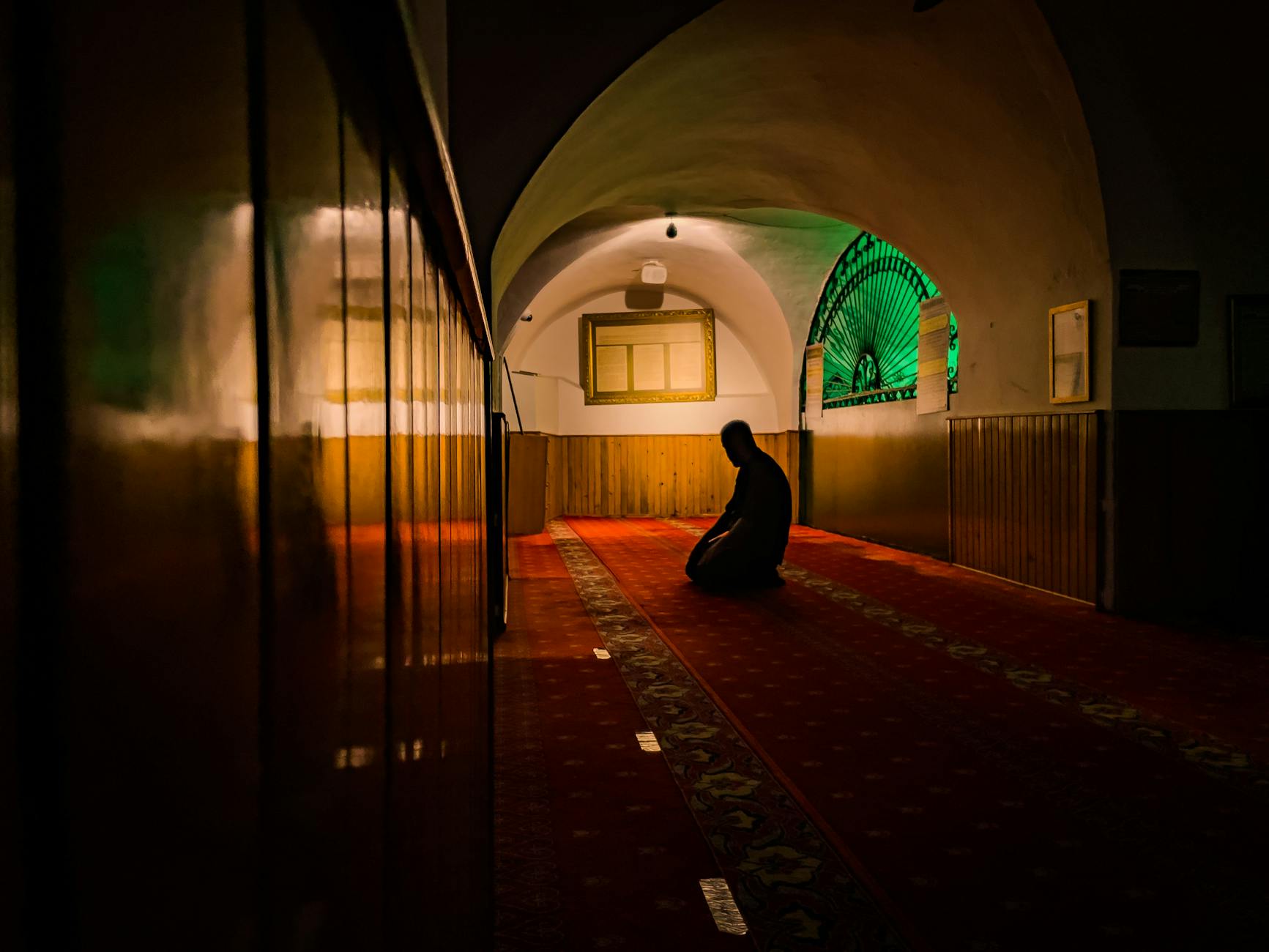 a person praying while kneeling in a mosque